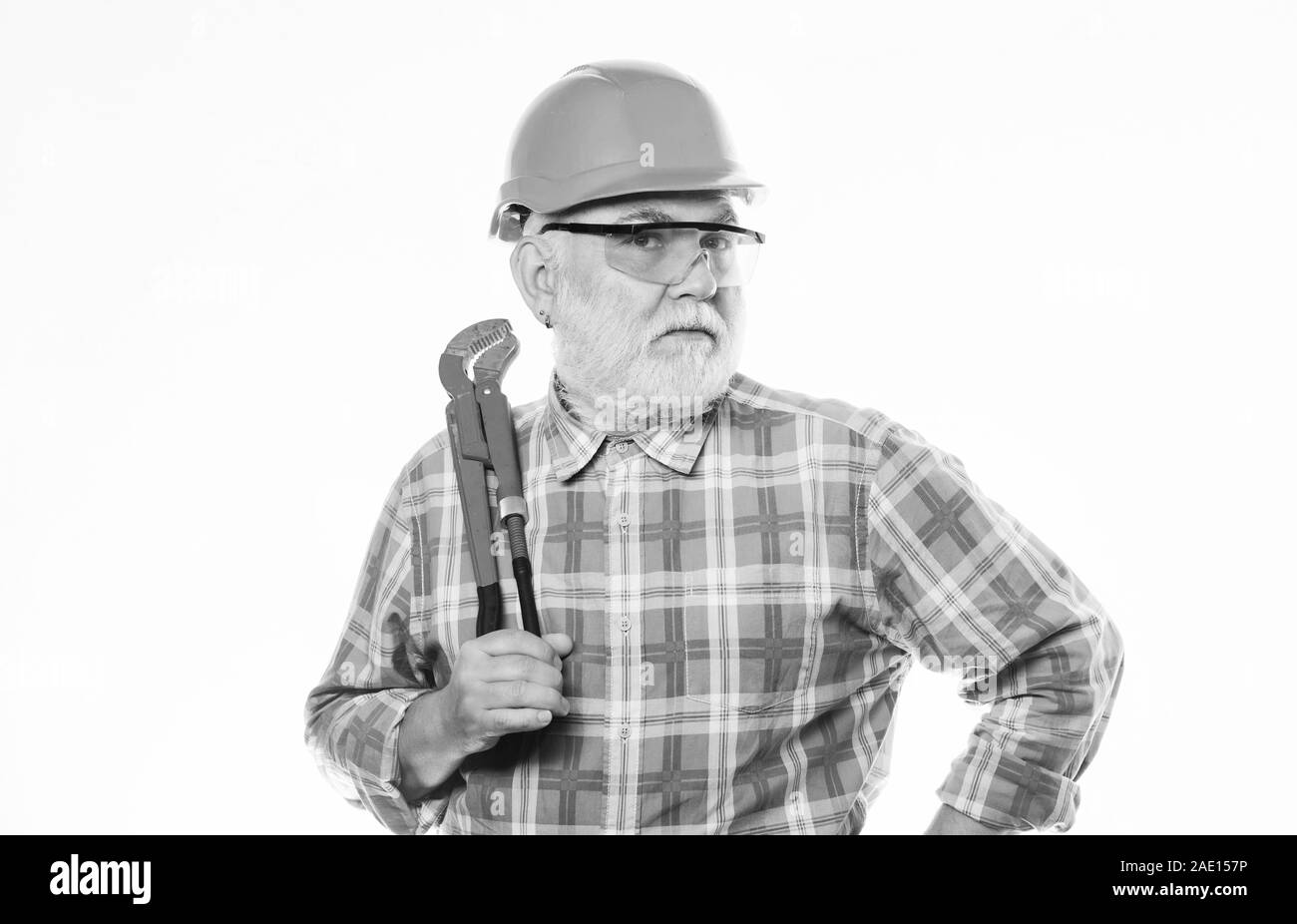 professional repairman in helmet with gas wrench. build and