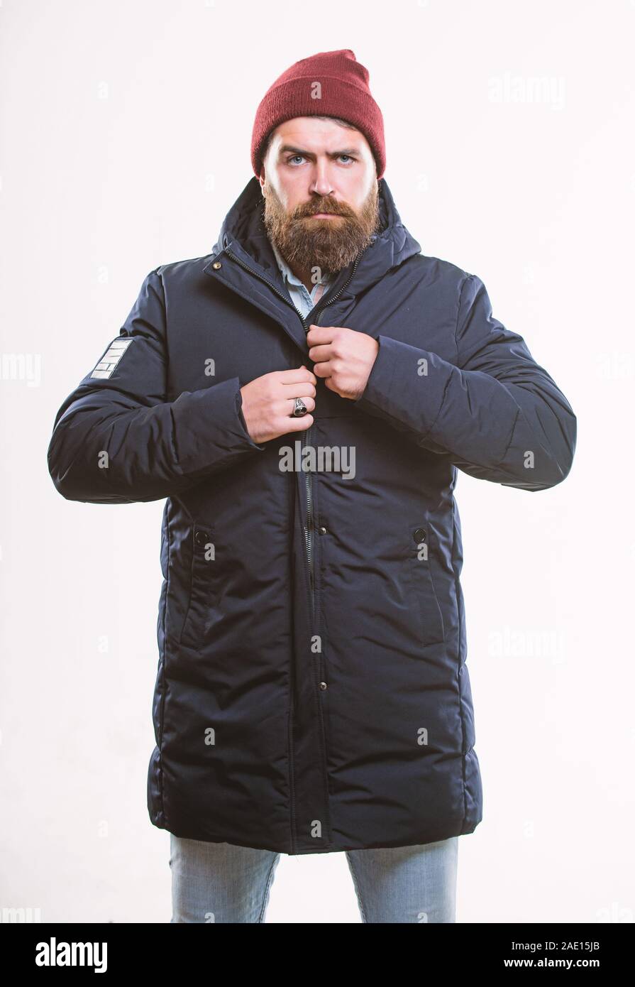 Stylish and comfortable. Guy wear hat and black winter jacket. Hipster  style menswear. Hipster outfit. Man bearded hipster stand in warm black  jacket parka isolated on white. Hipster modern fashion Stock Photo -