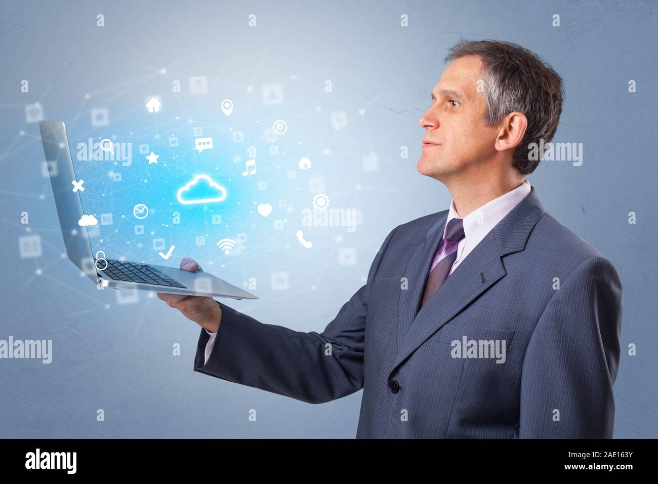 Man holding laptop projecting notifications, symbols and information based on cloud technology system Stock Photo