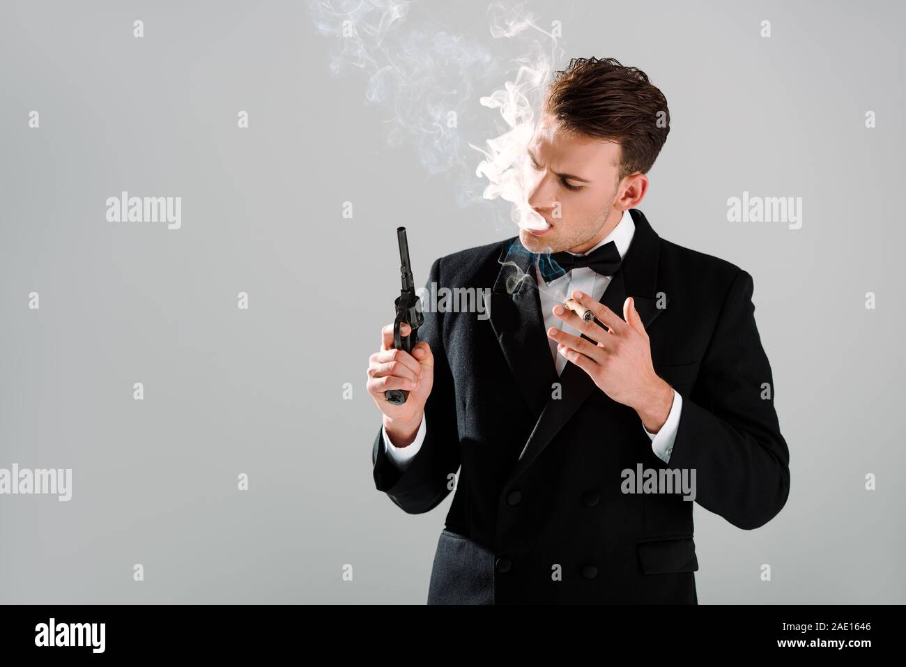 Dangerous Man In Suit With Bow Tie Holding Gun While Smoking Cigar dangerous-man-in-suit-with-bow-tie-holding-gun-while-smoking-cigar