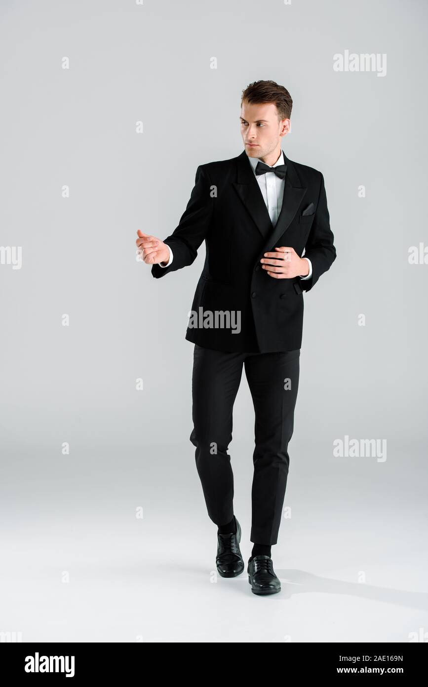 handsome and rich man in suit standing and gesturing on white Stock