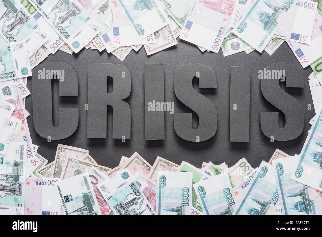 top view of word crisis in frame of dollar and euro banknotes on black ...