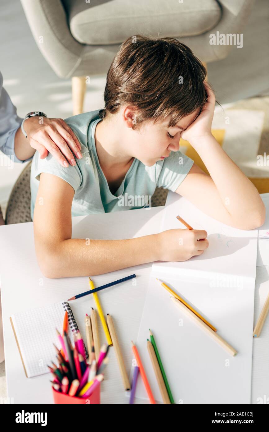 cropped view of child psychologist touching sad kid with dyslexia Stock Photo