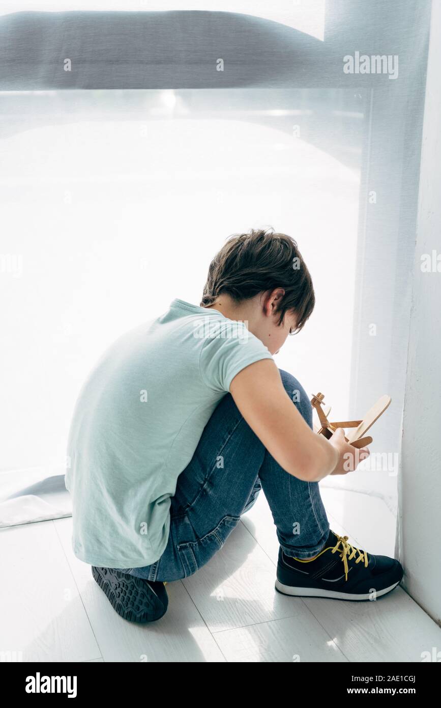 kid with dyslexia sitting on floor and playing with wooden plane Stock ...