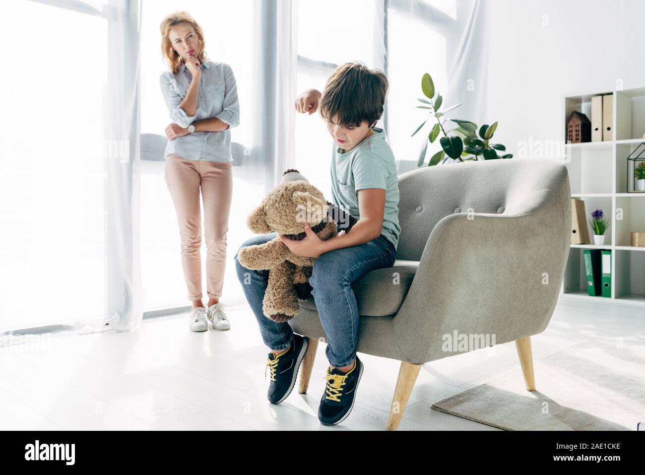 angry kid with dyslexia punching teddy bear and child psychologist ...