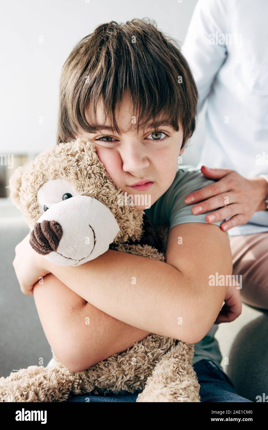 kid with dyslexia holding teddy bear and child psychologist hugging him ...