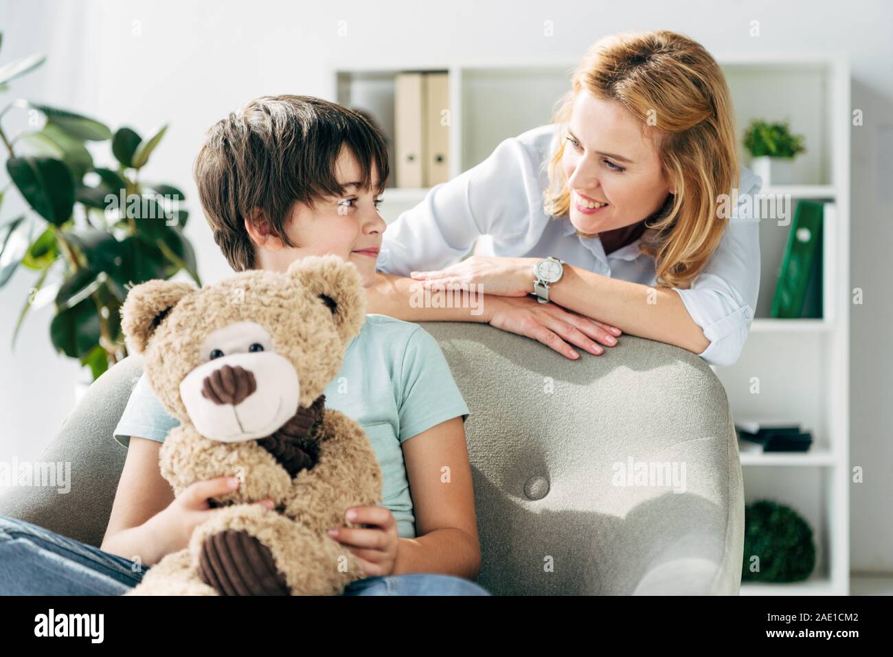 kid with dyslexia holding teddy bear and child psychologist talking ...