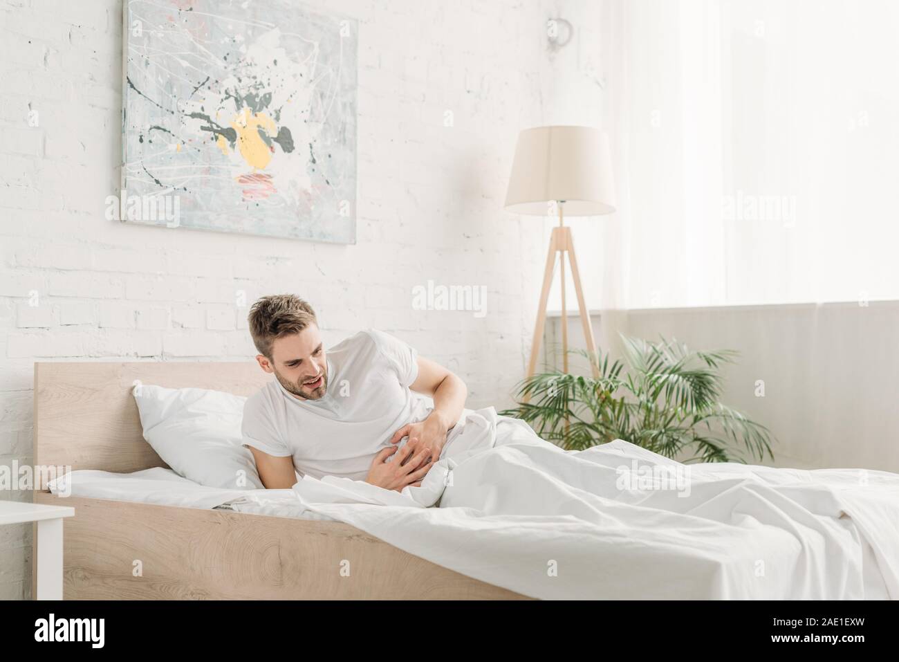 Young Man Touching Stomach While Suffering From Abdominal