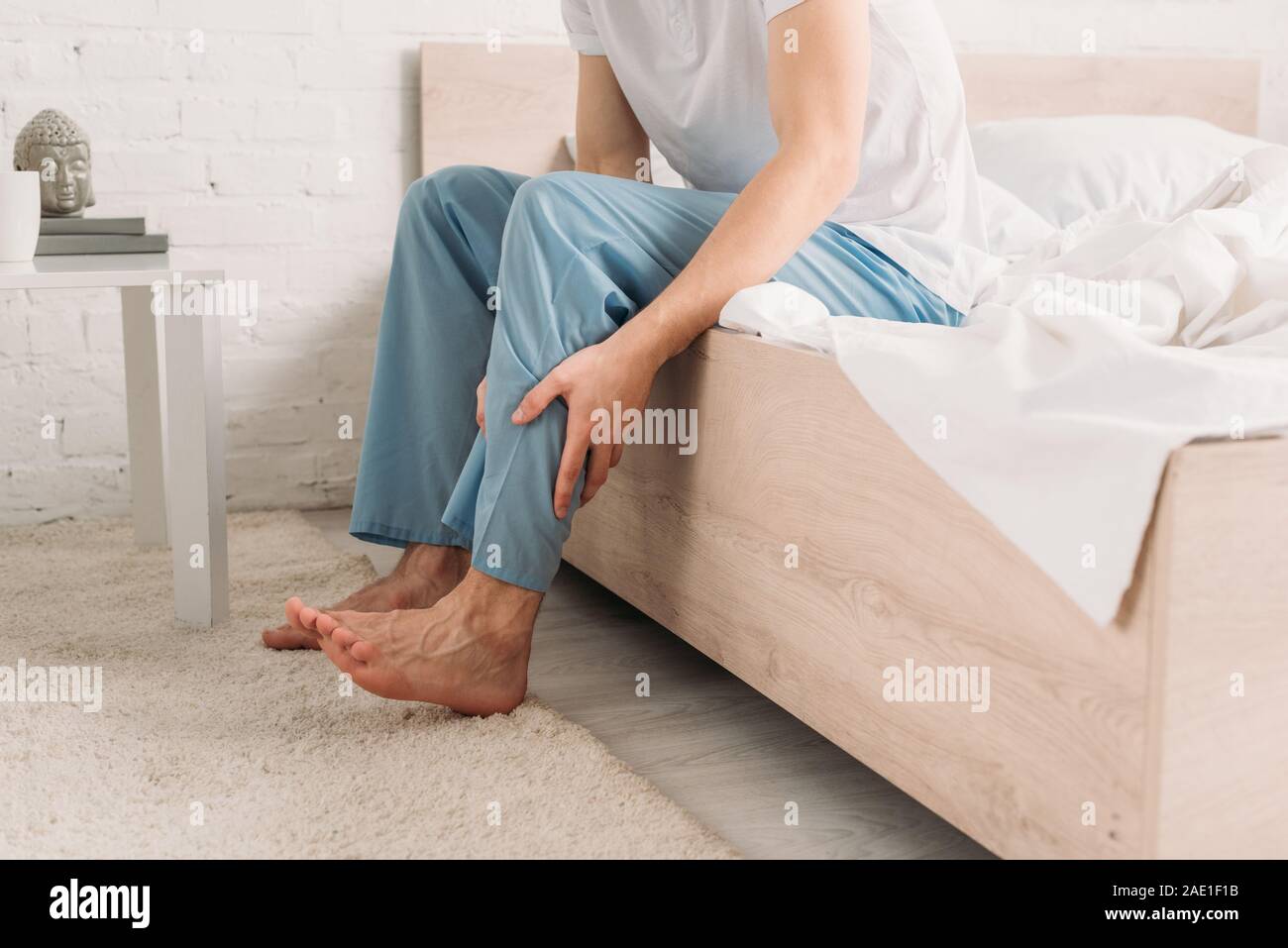 cropped view of man touching leg while suffering from calf muscle pain Stock Photo