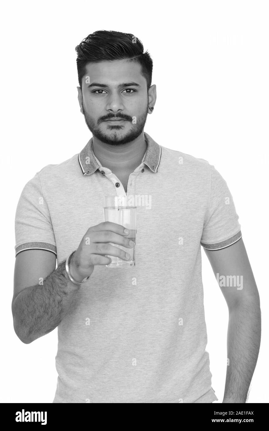 Young handsome Indian man holding glass of water Stock Photo - Alamy