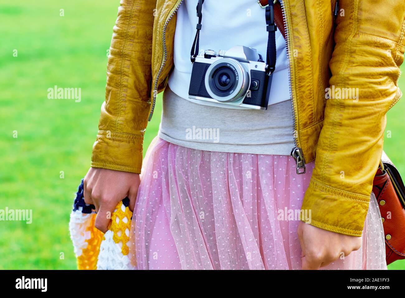 Girl wearing an old film camera on the neck strap Stock Photo - Alamy