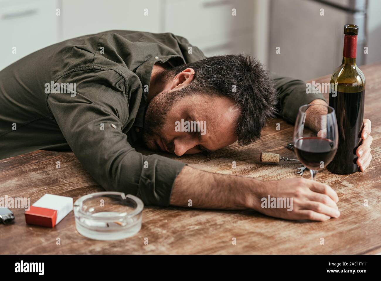 Drunk man sleeping on table with wine and cigarettes Stock Photo - Alamy