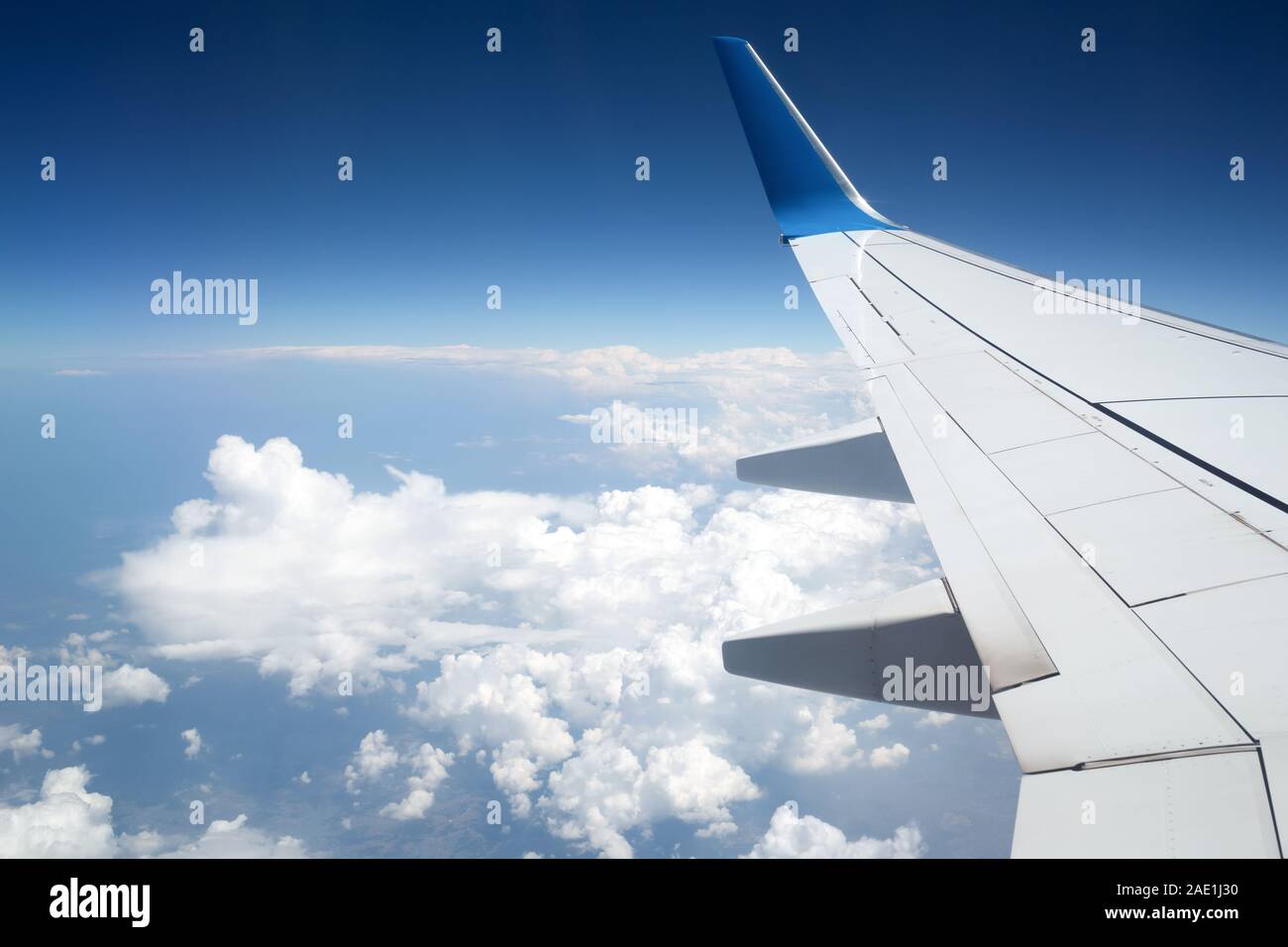 The wing of airplane in blue sky and above clouds Stock Photo - Alamy