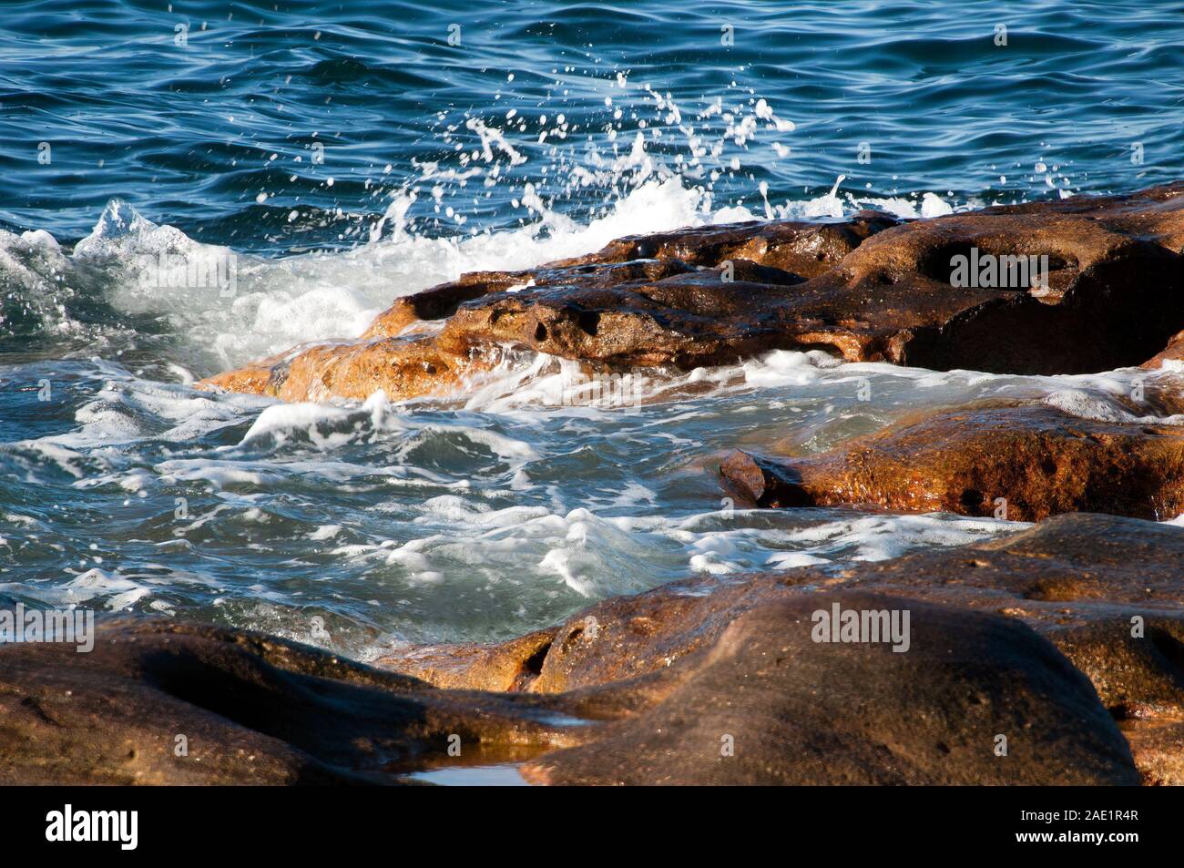 Sydney Australia, gentle waves breaking over rocks in Sydney Harbour ...