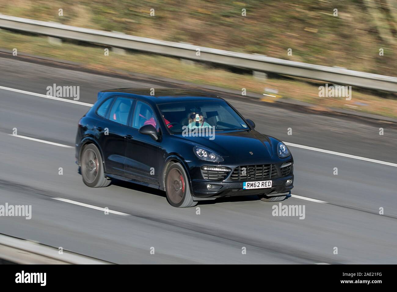 Blurred moving car PORSCHE CAYENNE traveling at speed on the M61 motorway Slow camera shutter speed vehicle movement Stock Photo