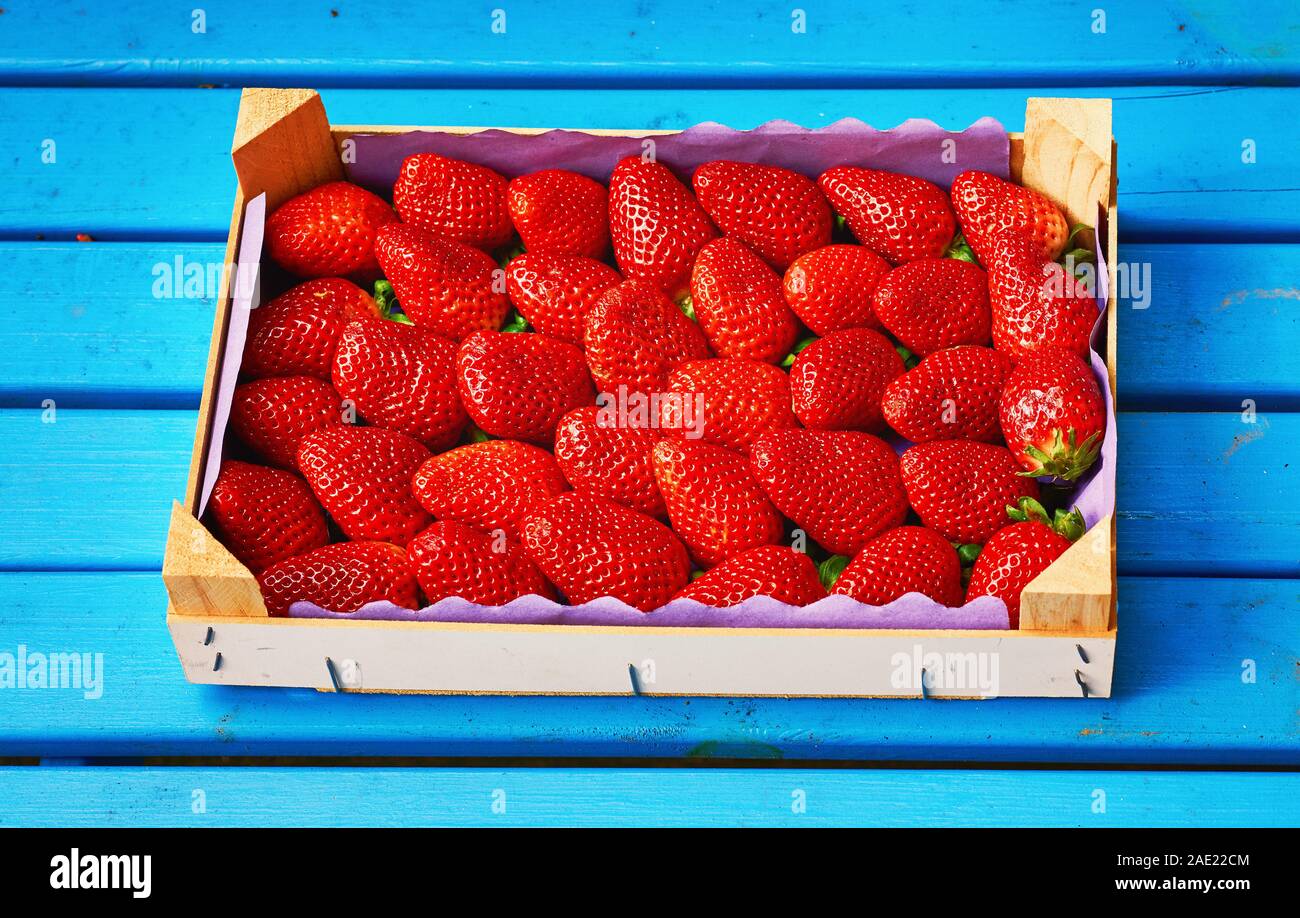 Fresh red strawberry with wooden box and blue wood background Stock ...