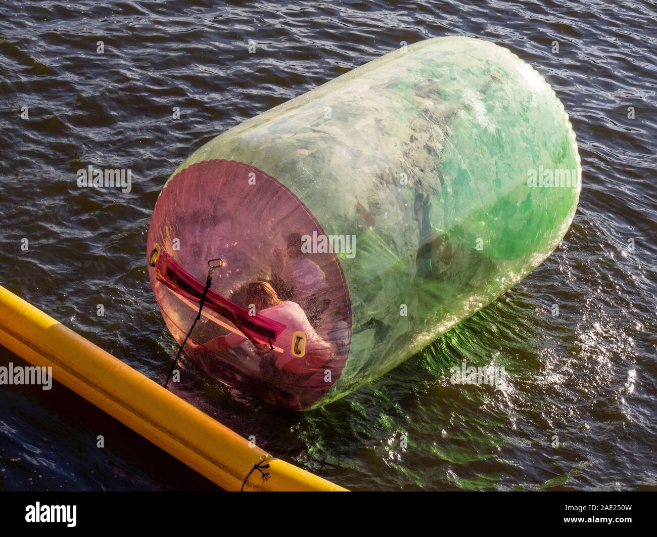 People in a inflatable cylindrical water ball zorbing in the Vltava River Prague Czech Republic. Stock Photo