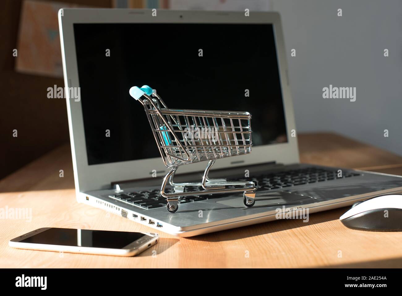 Shopping cart on laptop computer keyboard. Online shopping concept
