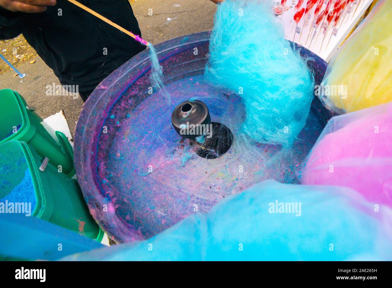 Hand rolling cotton candy in candy floss machine. Candyfloss making Stock Photo