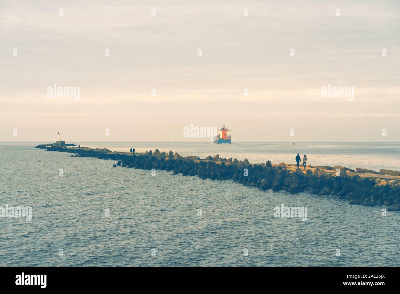 Breakwater with a lighthouse at the mouth of the river Stock Photo