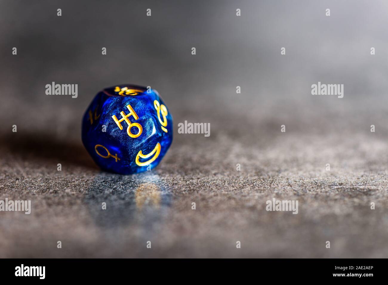Blue Astrology Dice with symbol of the planet Uranus on grey background Stock Photo