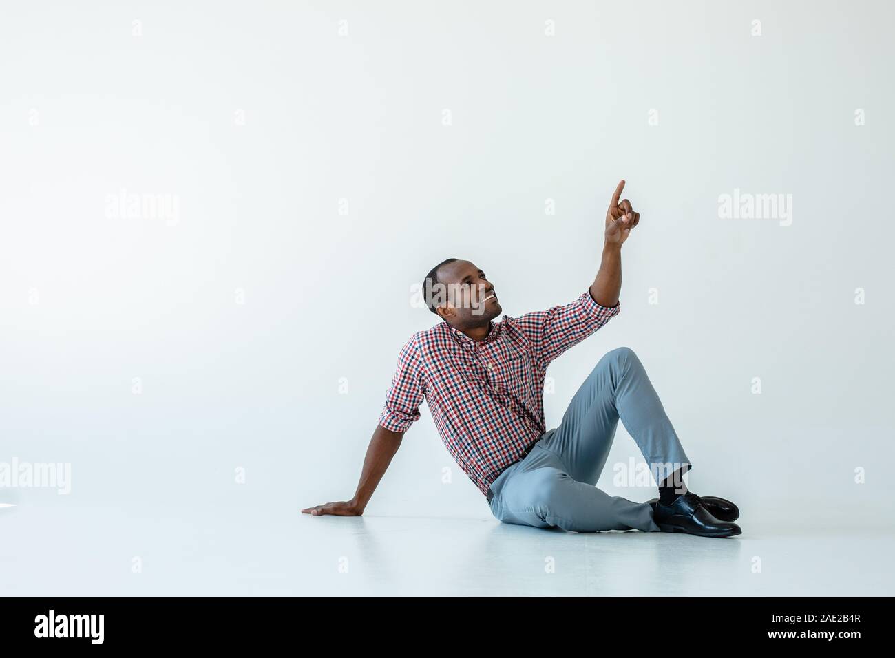 Cheerful afro american man sitting ont he floor Stock Photo