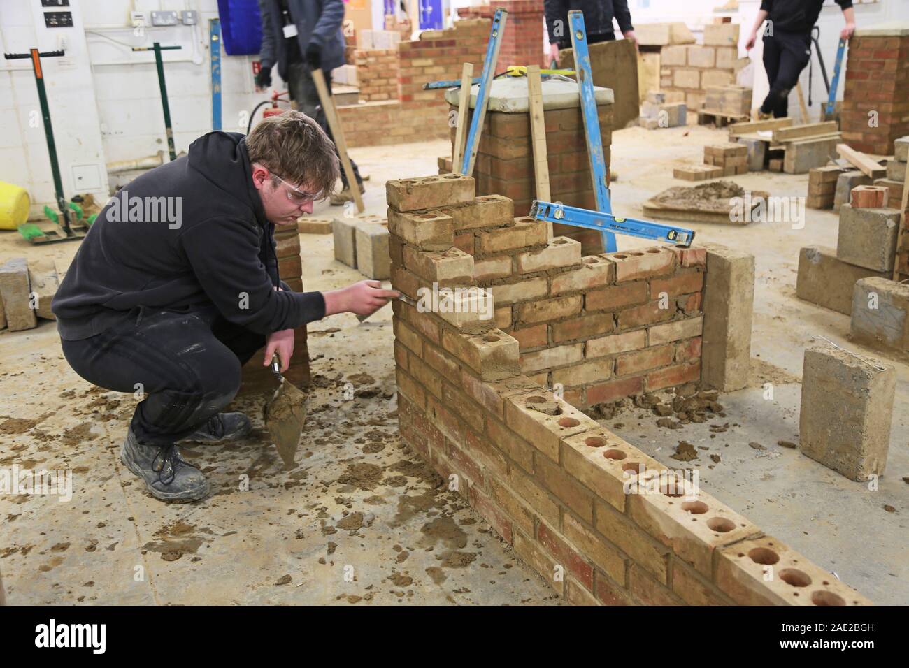 A bricklaying student works on a simple wall section at Suffolk New