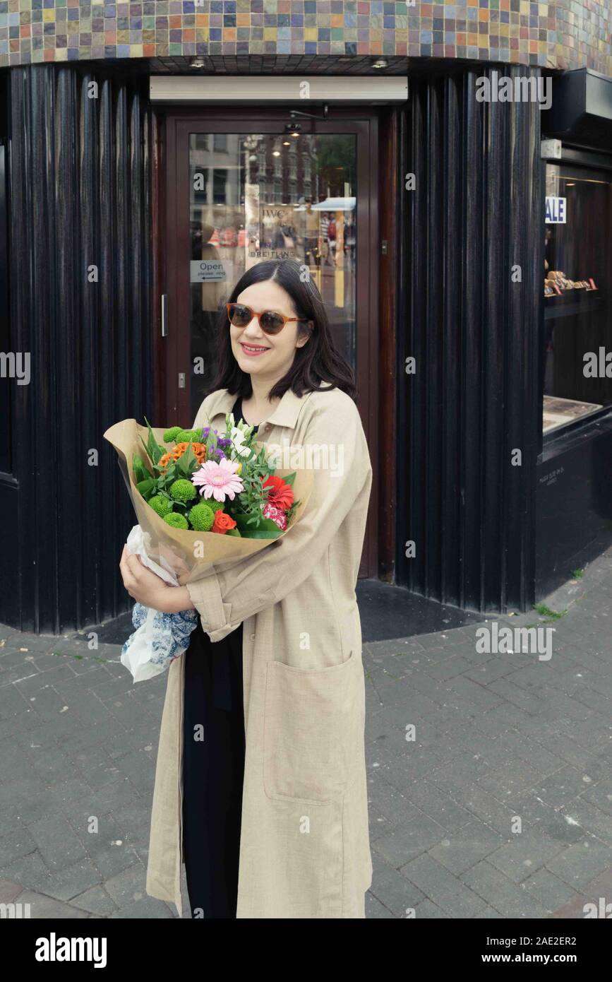 Woman holding flowers, Flower market, Amsterdam, Netherlands Stock Photo