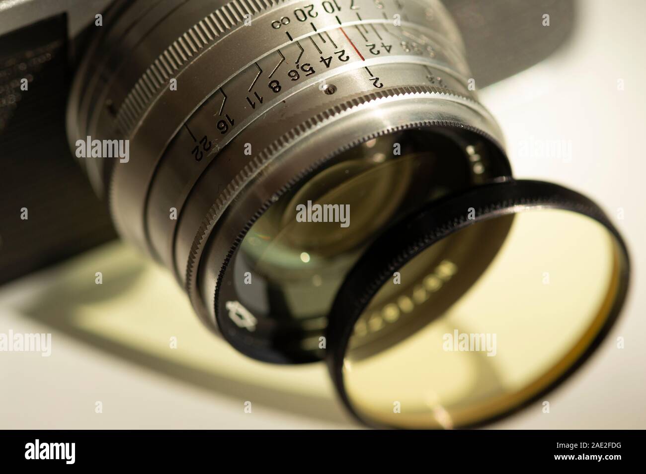 Close up of Russian old vintage silver manual camera lens and detached separated yellow filter as classic retro photography concept. Stock Photo