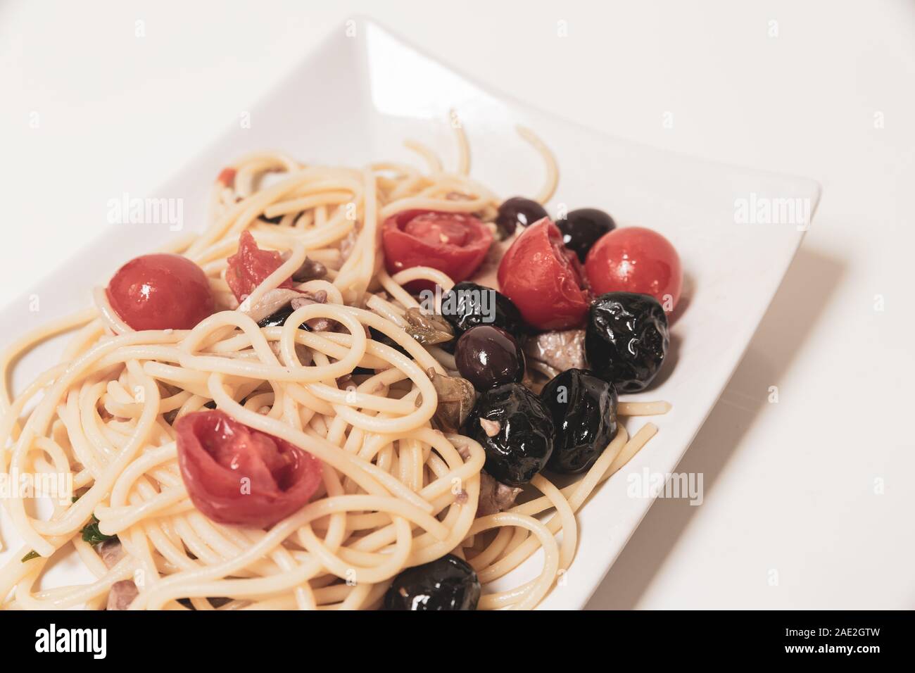 Spaghetti with sauce consisting of cherry tomatoes, capers, olives Stock Photo Alamy
