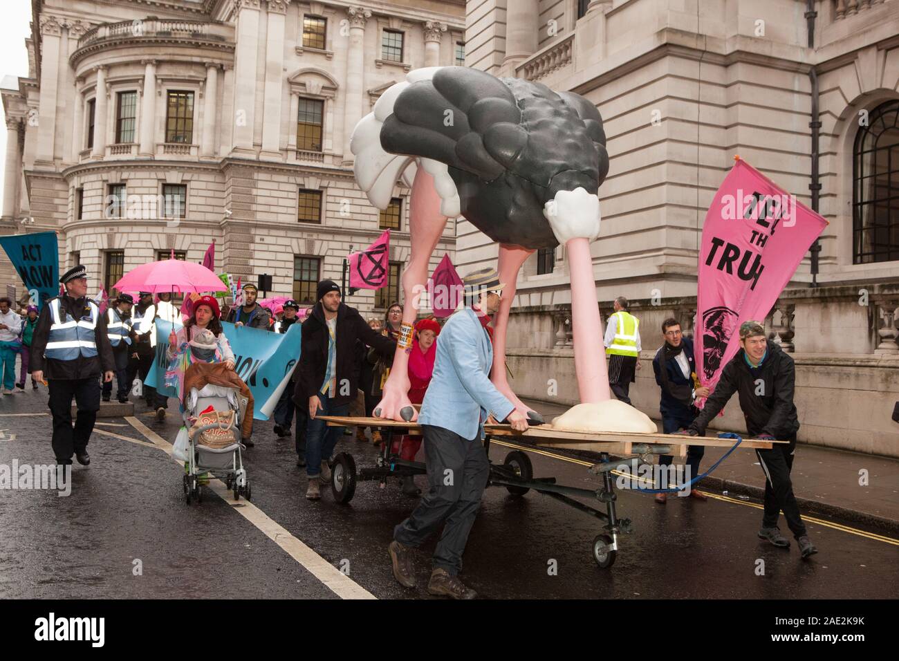 London, UK, 6 December 2019: Extinction Rebellion protestors paraded through Westminster today with a 4-metre high ostrich with it's head in the sand. Symbolising the main political parties' attitudes to the climate crisis, the ostrich was accompanied by a flash mob who danced to 'Where's Your Head At' and 'Staying Alive' outside the party headquarters of the Conservatives, Liberal Democrats and Labour Party. Anna Watson/Alamy Live News Stock Photo