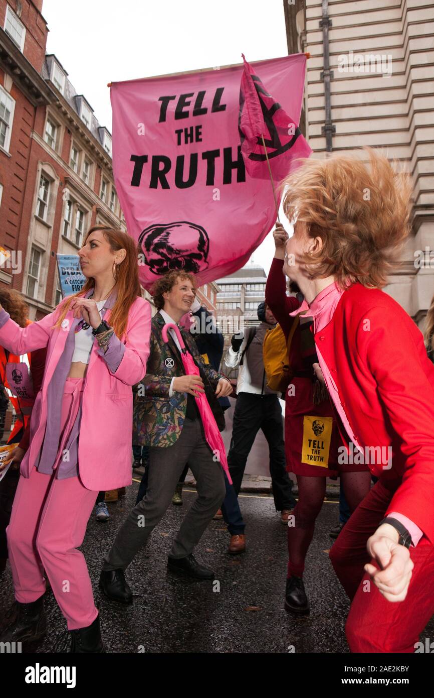 London, UK, 6 December 2019: Extinction Rebellion protestors paraded through Westminster today with a 4-metre high ostrich with it's head in the sand. Symbolising the main political parties' attitudes to the climate crisis, the ostrich was accompanied by a flash mob who danced to 'Where's Your Head At' and 'Staying Alive' outside the party headquarters of the Conservatives, Liberal Democrats and Labour Party. Anna Watson/Alamy Live News Stock Photo