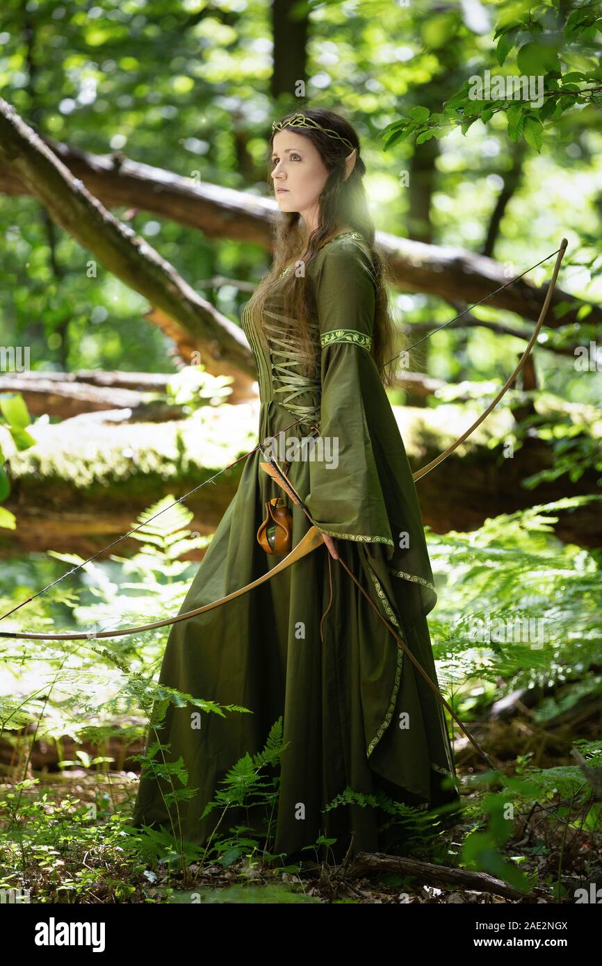 Elf woman in a green dress in the forest Stock Photo