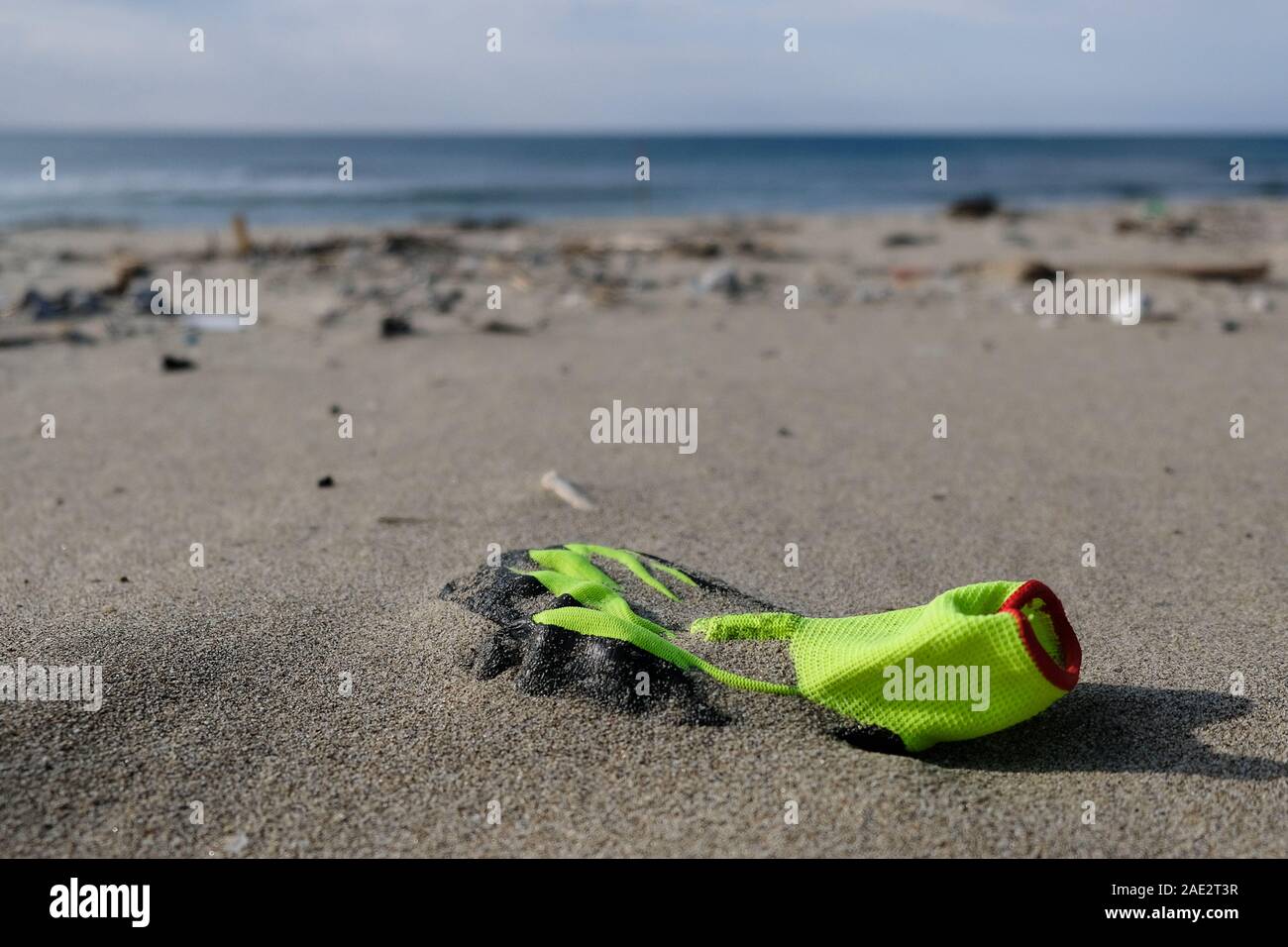 Plastic working gloves on sandy sea coast,planet pollution concept Stock Photo