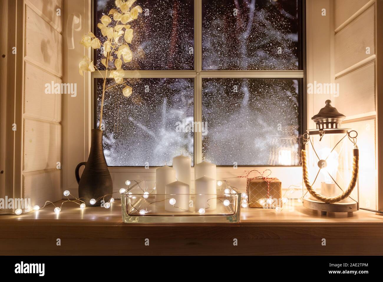 Beautiful Burning Candles And Fairy Lights On Windowsill Indoors