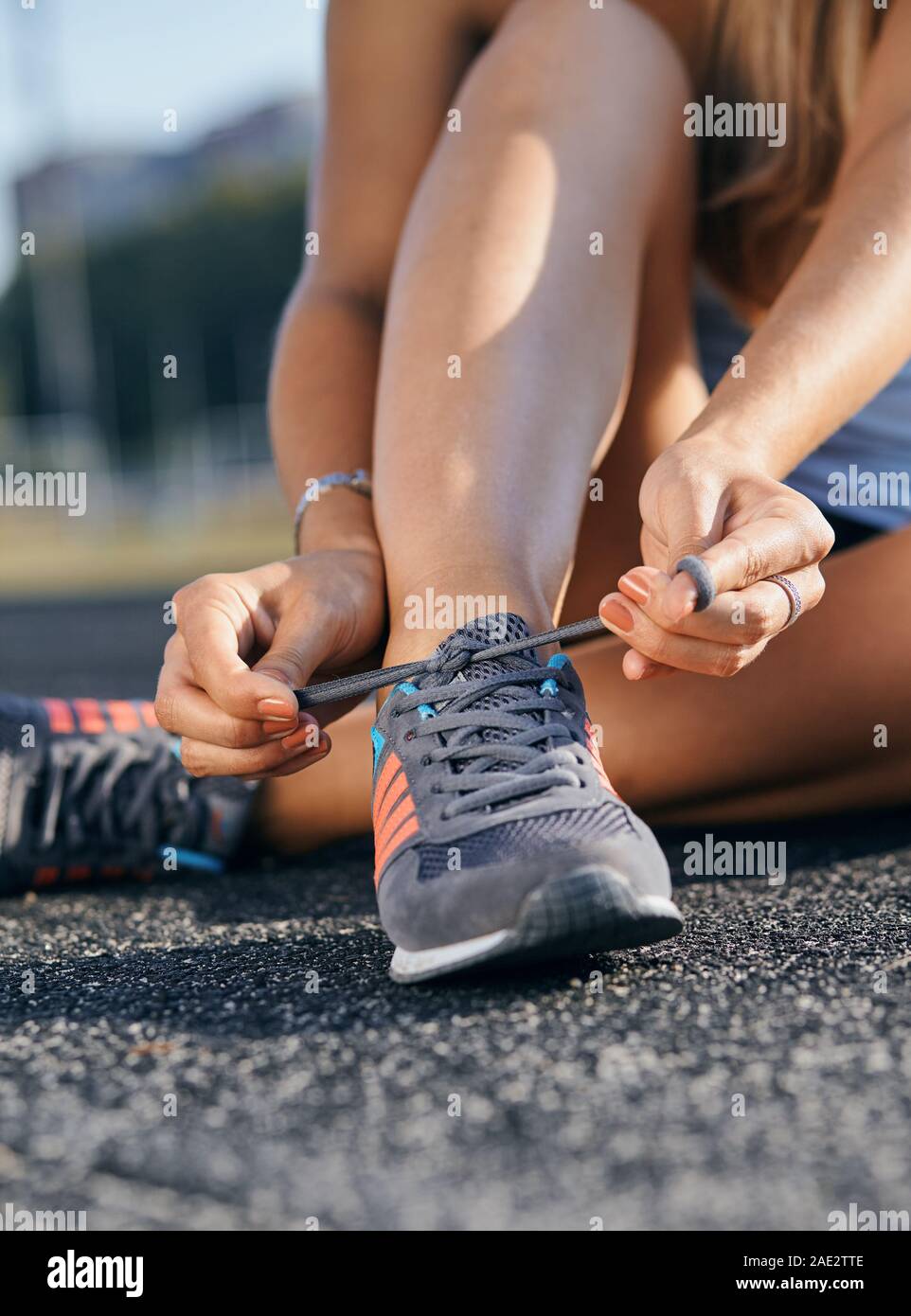 woman tying her running shoes before running Stock Photo