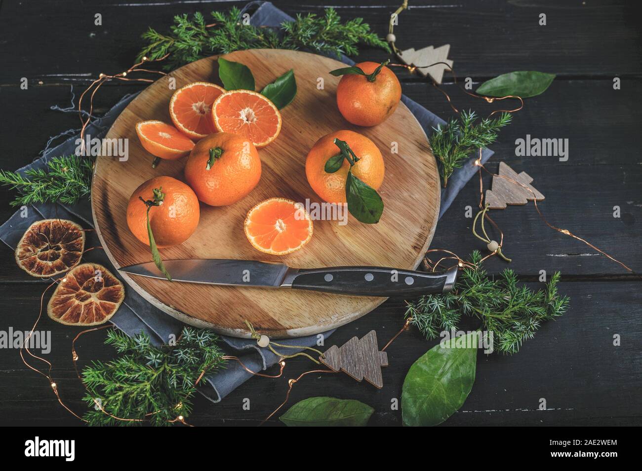 Tangerines on a festive Christmas rustic table setting with vintage dishes on a dark background. Stock Photo