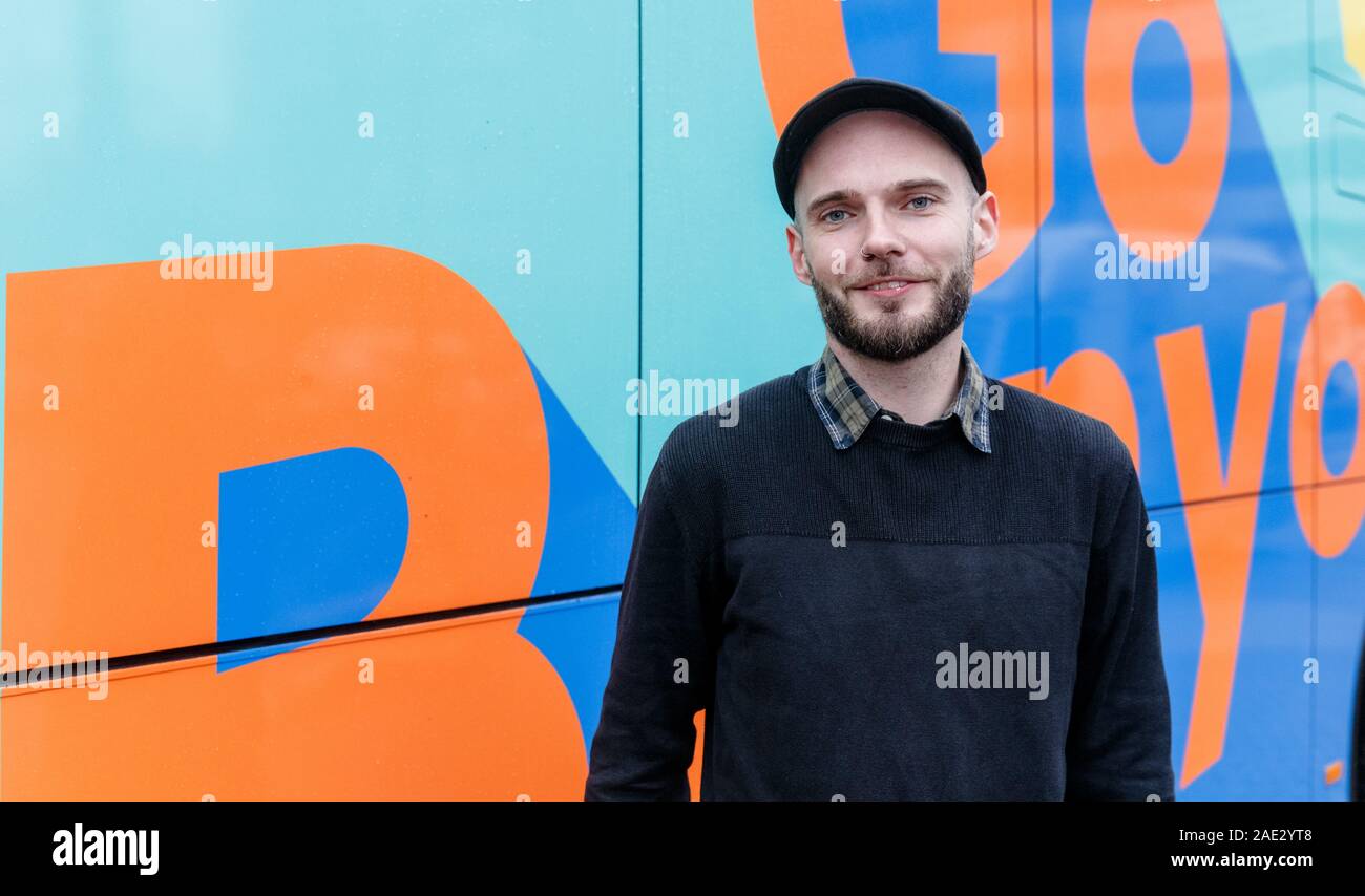 Hamburg, Germany. 06th Dec, 2019. Christian Poelmann, GoBanyo managing director, stands in front of the shower bus logo. The vehicle, a crowdfunded project, offers three washrooms and showers for the homeless. Credit: Markus Scholz/dpa/Alamy Live News Stock Photo