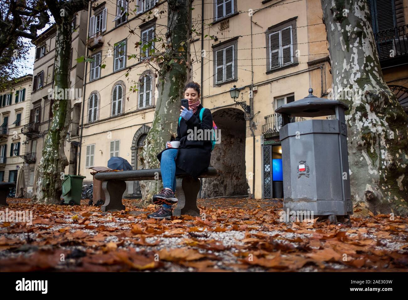 LUCCA, ITALY - NOVEMBER 24, 2019: unknown woman answers the phone while  sipping a coffee in Piazza Napoleone, commonly referred to as Piazza  Grande, i Stock Photo - Alamy