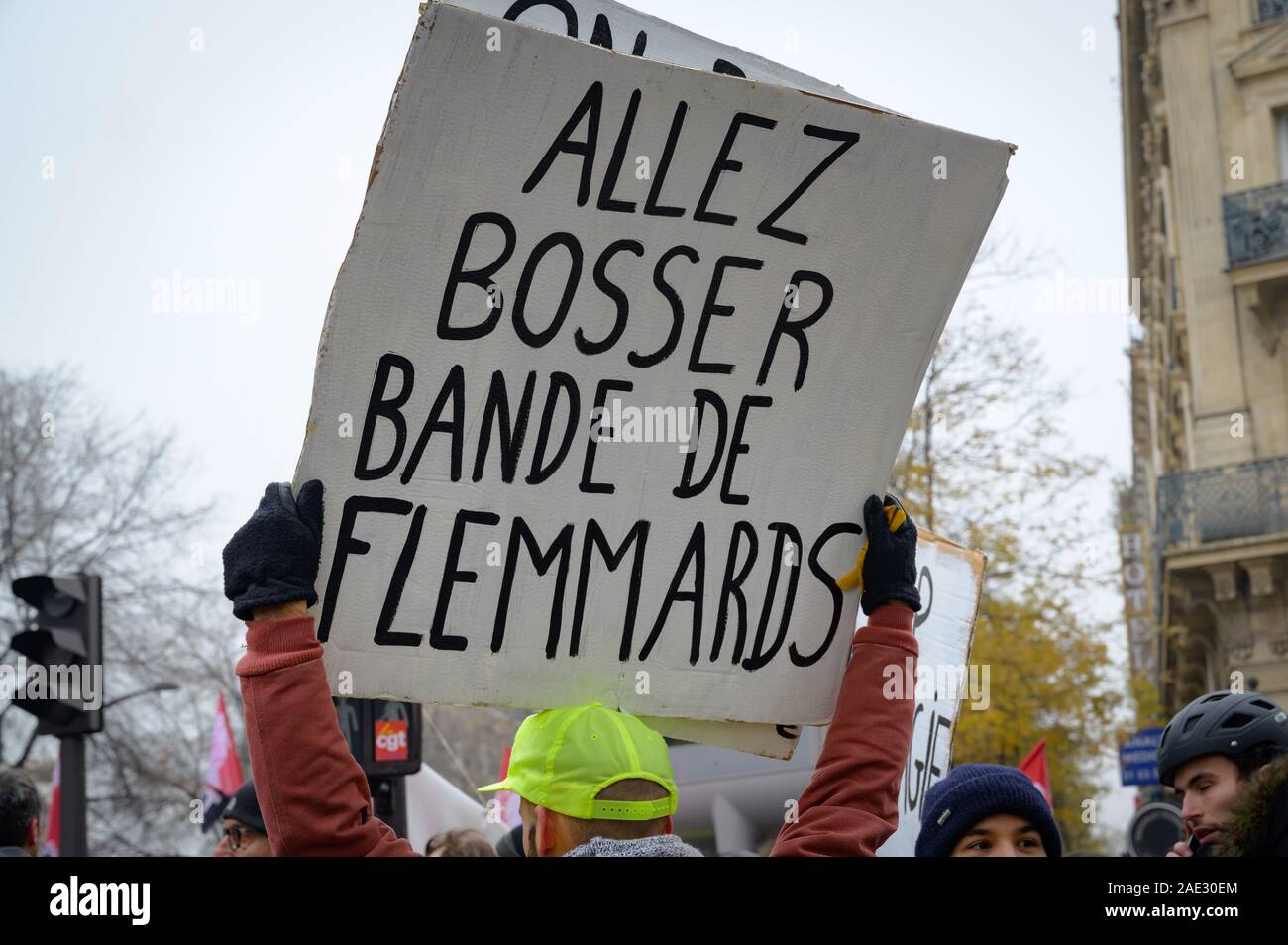PARIS, FRANCE, DECEMBER 05 2019 : a protester with a sign 'go work lazy people' during a 'Gilets Jaunes' (Yellow Vests) protest. Stock Photo