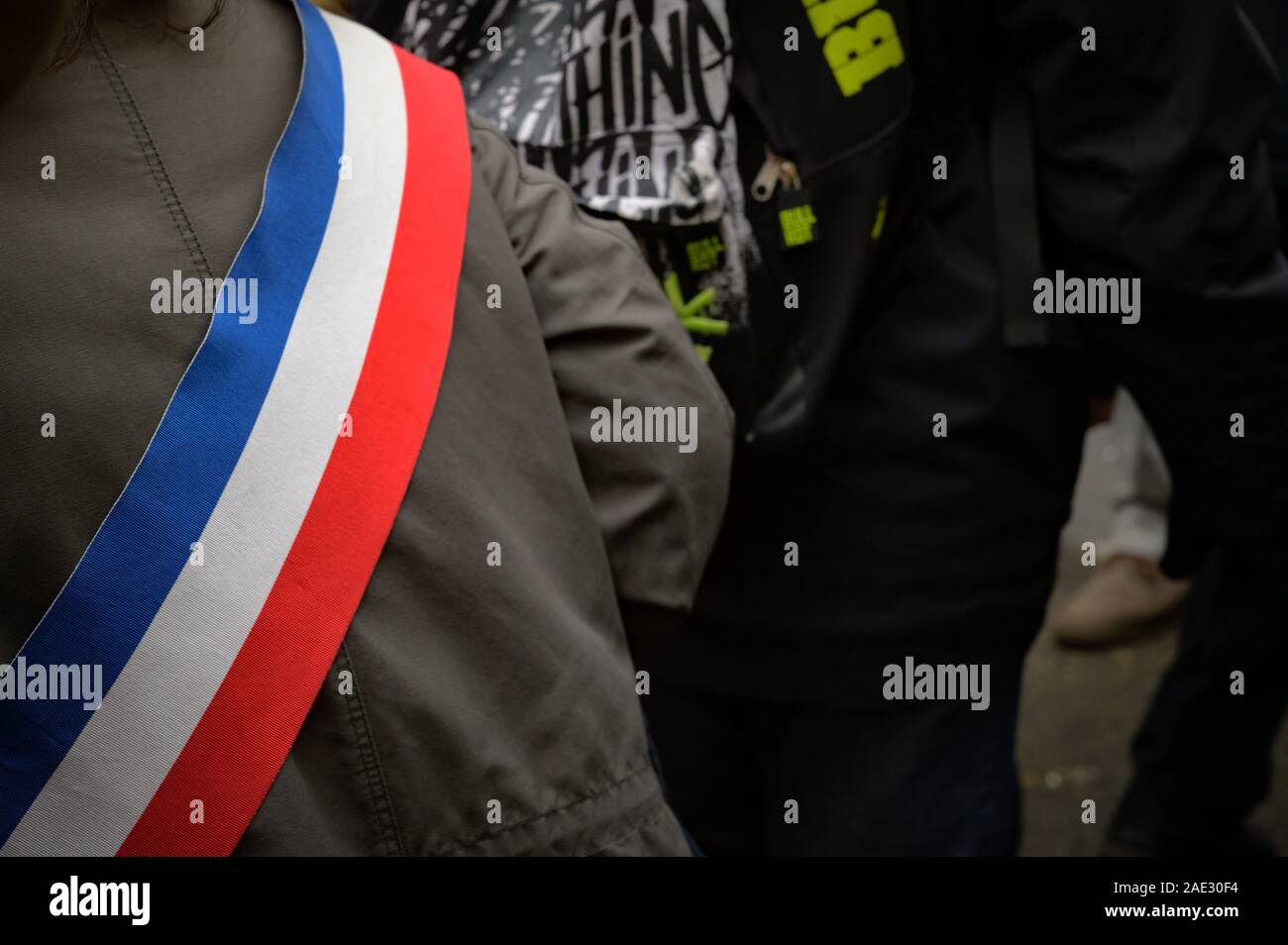 PARIS, FRANCE, DECEMBER 05 2019 : a protestor wearing a blue white red streamer during a 'Gilets Jaunes' (Yellow Vests) protest. Stock Photo