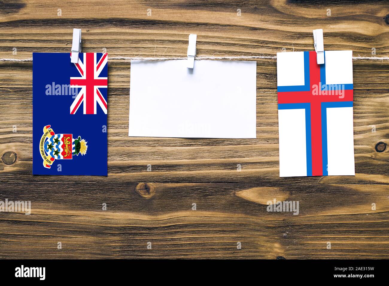 Hanging flags of Cayman Islands and Faroe Islands attached to rope with ...