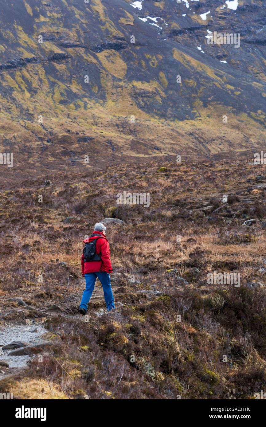 Woman walking at Black Cuillin and Fairy Pools, river Brittle, Isle of Skye, Scotland, UK in March Stock Photo