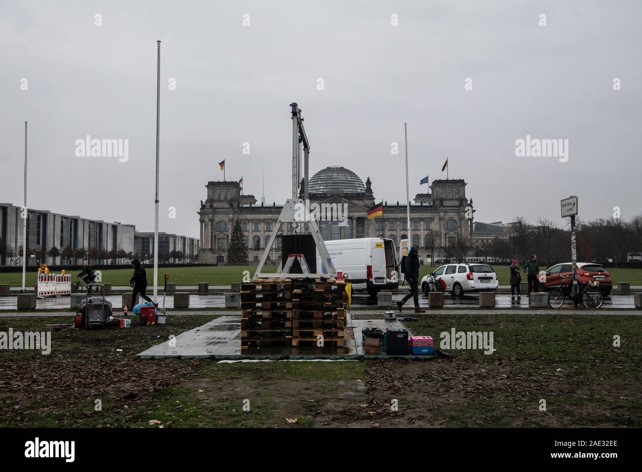 Berlin, Germany. 06th Dec, 2019. Wooden pallets and a lifting device stand on a meadow not far from the Reichstag. The artists' collective 'Zentrum für politische Schönheit' (ZPS) had set up a controversial art installation there, which also included a column in which, according to ZPS information, the ashes of Holocaust victims could be seen. Since noon, members of the ZPS have been dismantling the installation. Credit: Paul Zinken/dpa/Alamy Live News Stock Photo