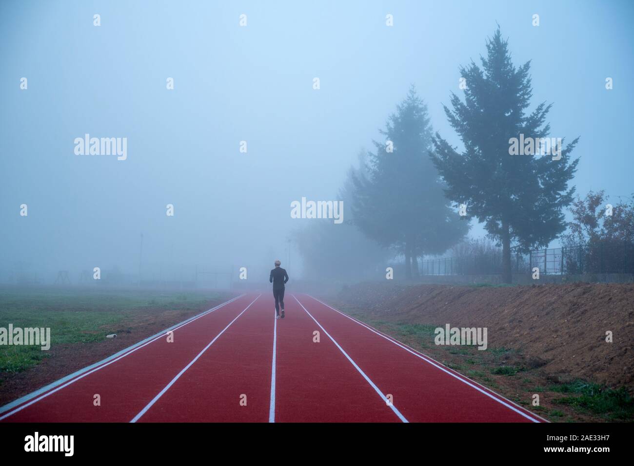 Professional athlete train at athletics running track in morning blue
