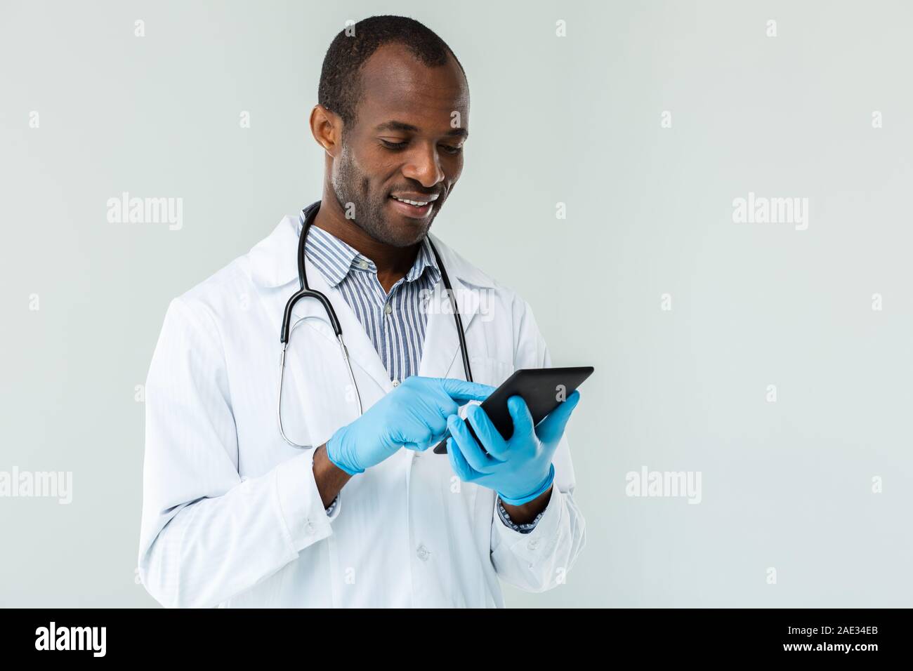 Positive doctor using his tablet Stock Photo