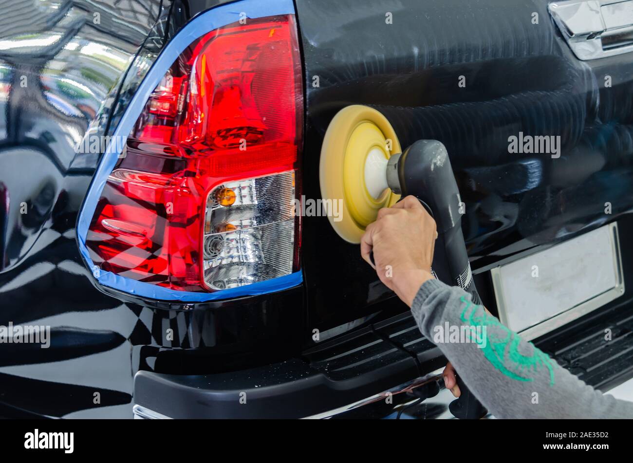 Remove black car scratches. A man holding an automobile polishing tool