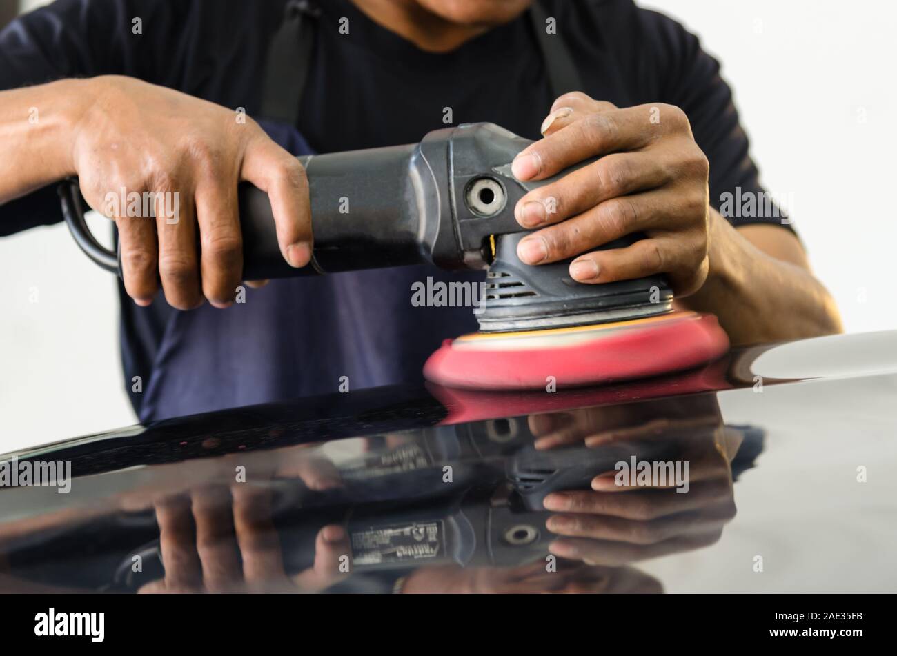 Remove black car scratches. A man holding an automobile polishing tool