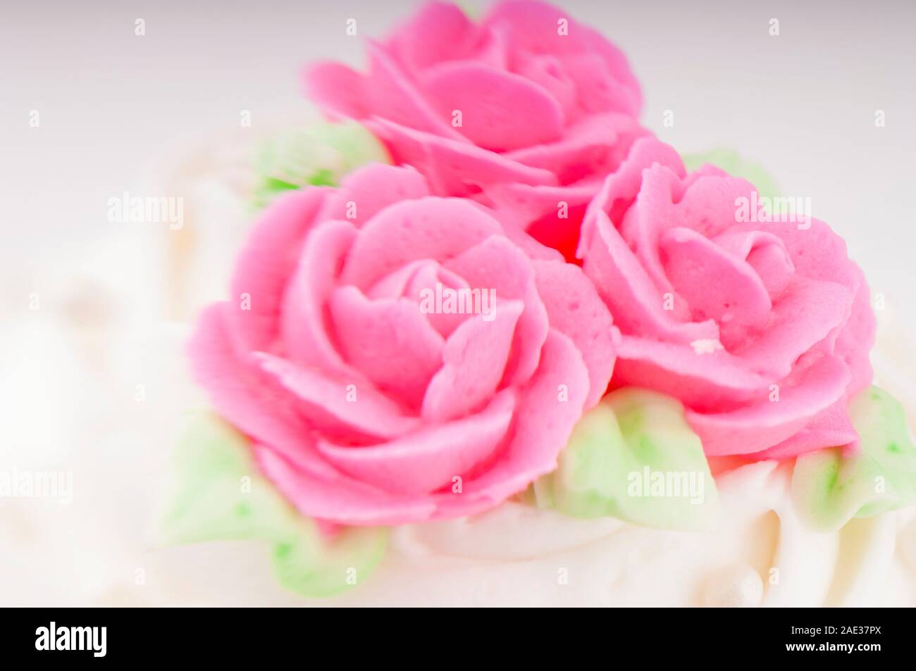 White and pink cake frosting detail with decorative flowers Stock Photo ...