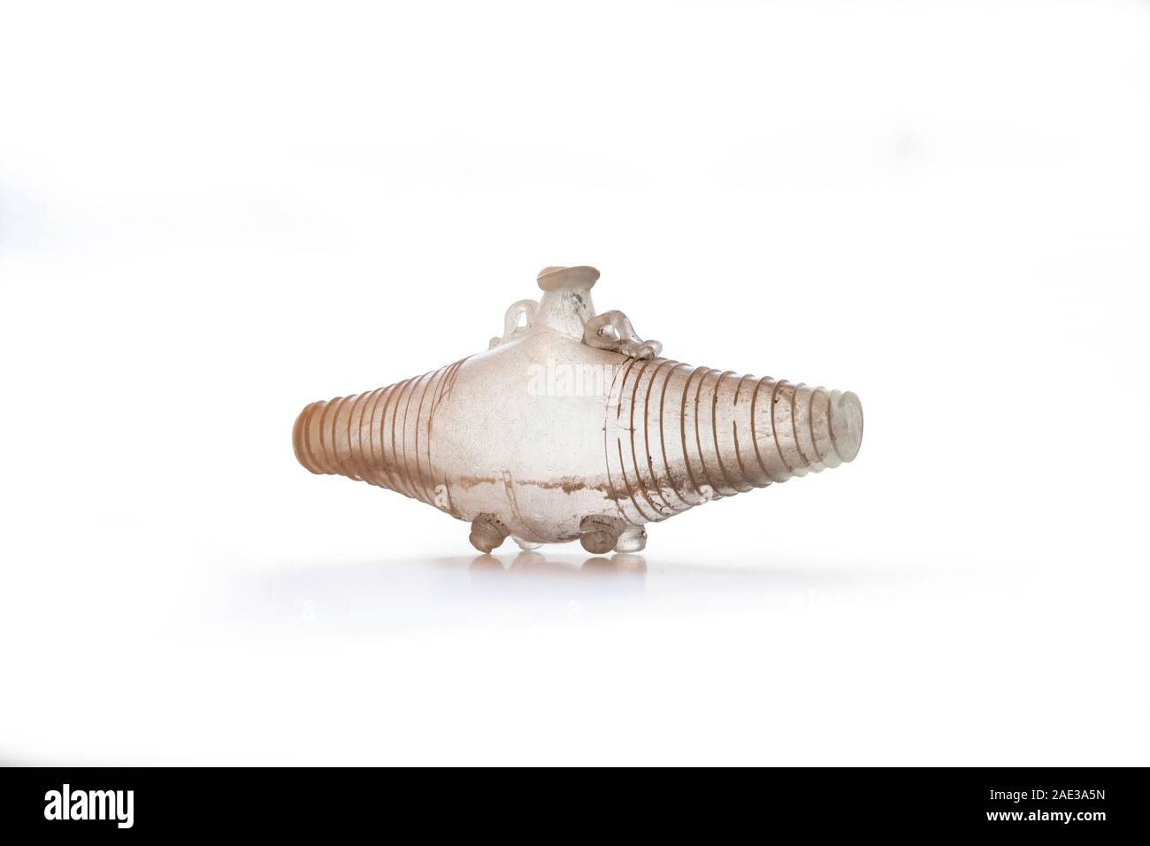 Ancient Roman glass jug in form of  barrel with glass thread decor. Natural-coloured Glass of the 1st and 2nd centuries AD. Clipping path for design p Stock Photo